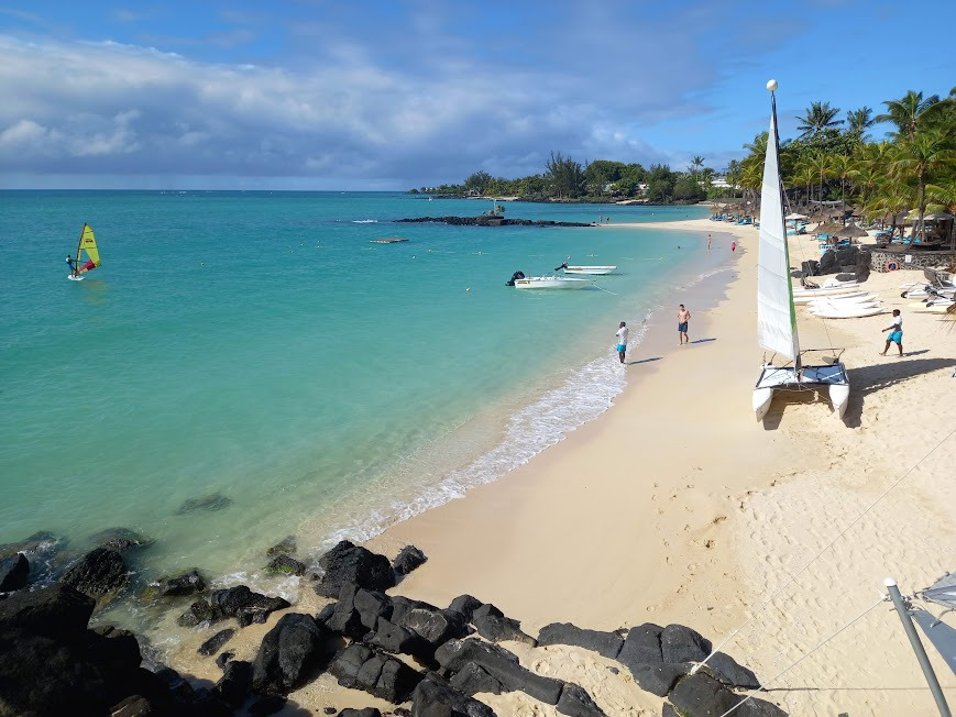 Mauritius Holiday Packages pristine beach with sailboat and turquoise waters perfect for water activities