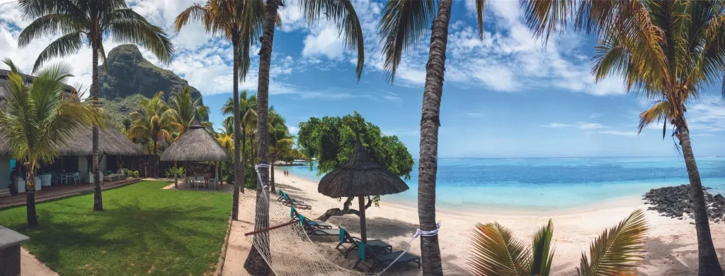 Panoramic view of Paradis Beachcombers villa with lush greenery palm trees and a pristine beach.