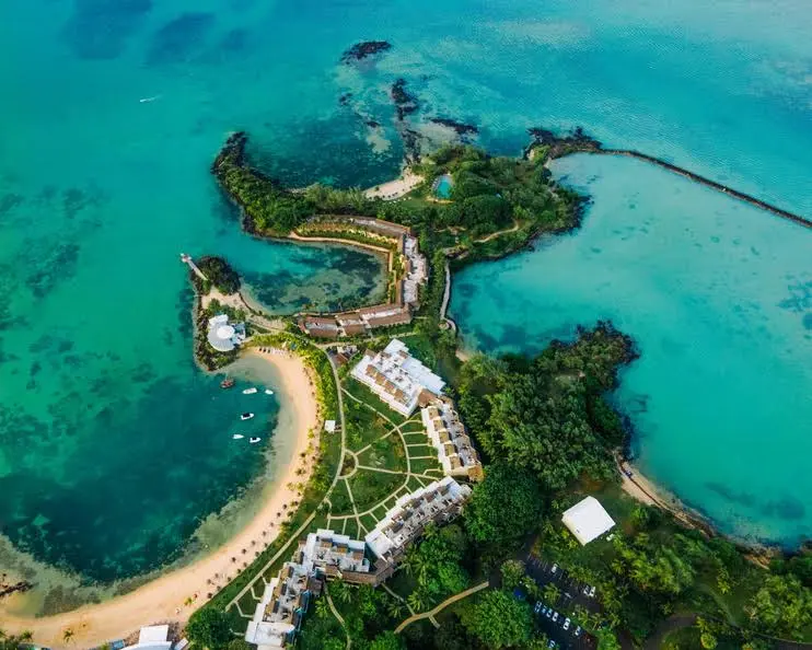 Aerial view of LUX Grand Gaube in Mauritius, with beachfront villas, lush greenery, and turquoise lagoons surrounding the resort.