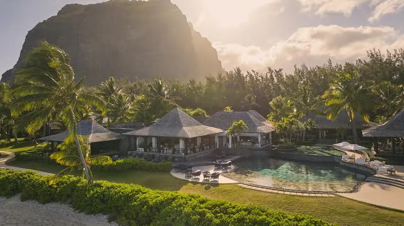 Beachfront view of LUX Le Morne in Mauritius with tropical villas, private pool, and Le Morne Brabant mountain in the background.